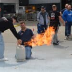 groep volgt instructies voor blusoefening in openlucht