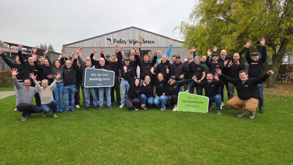 Groep medewerkers op een vrolijke groepsfoto met een bord met de tekst "Wij zijn een beestig team"